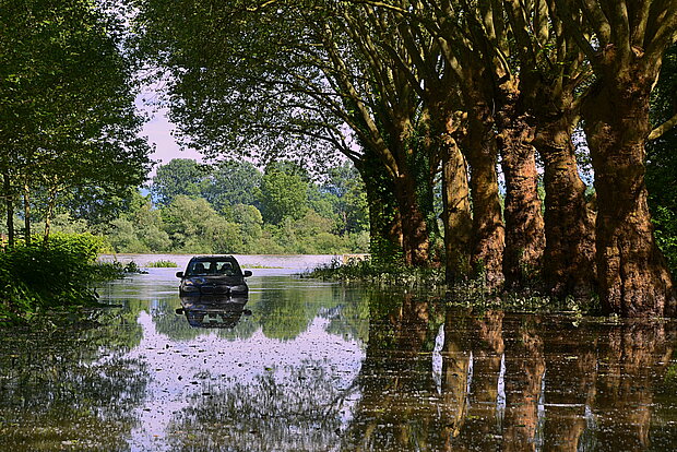 Auto in Baumallee im Hochwasser