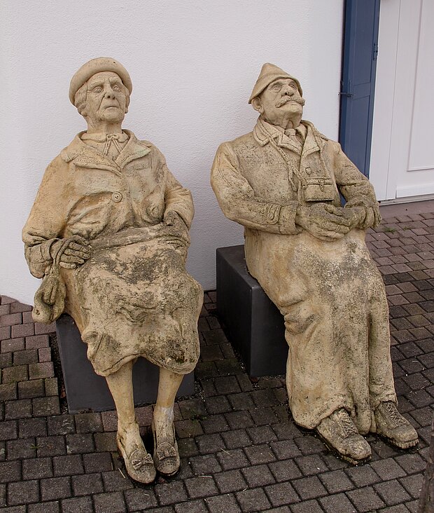 Skulptur von zwei alten sitzenden Leuten 