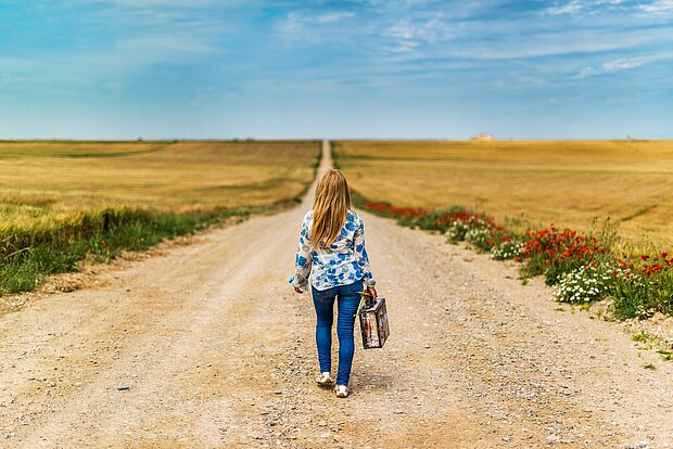 kleines Mädchen läuft allein einen Feldweg entlang