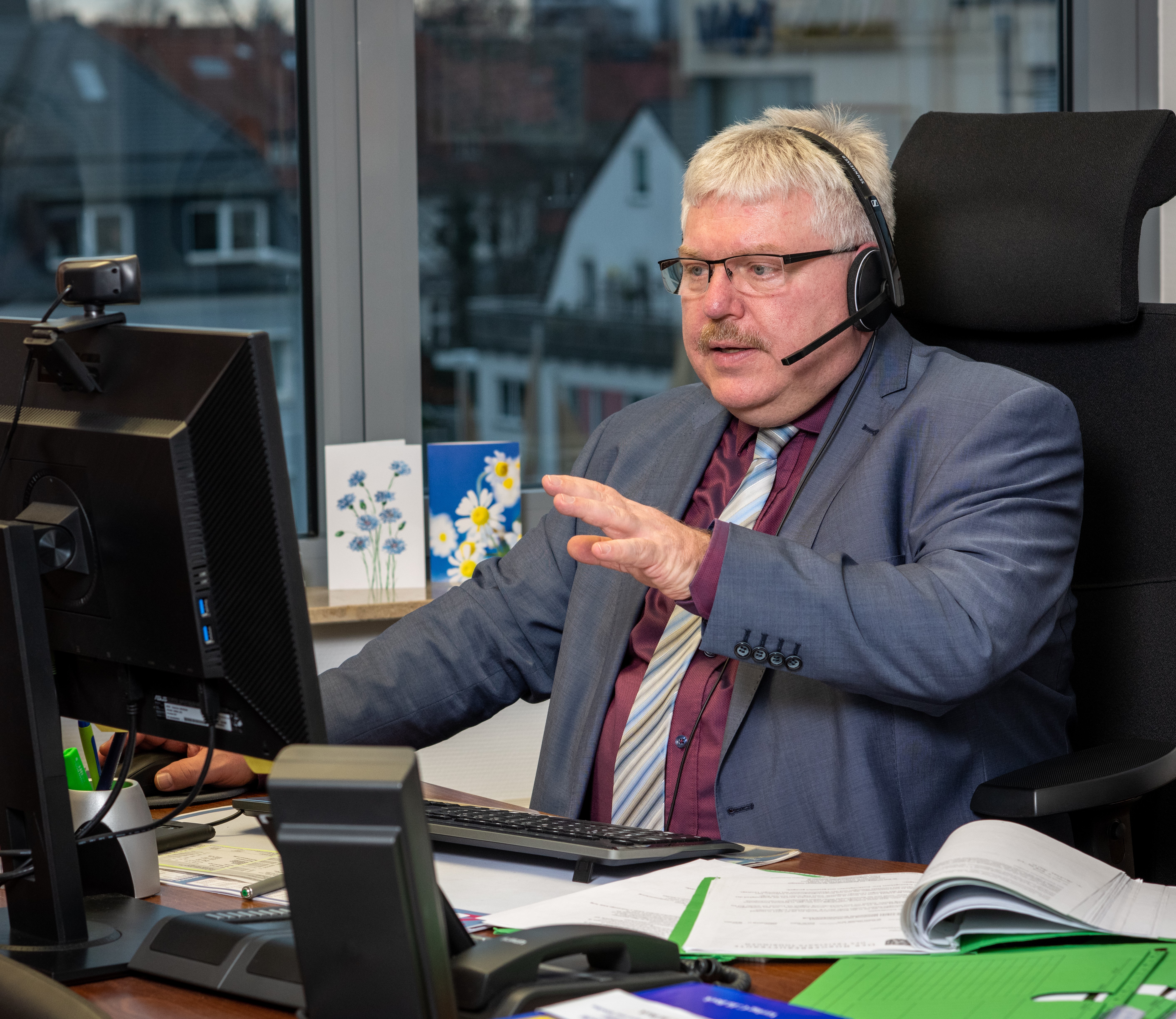 Dr. Herzberg mit Headset vor seinem Computer 