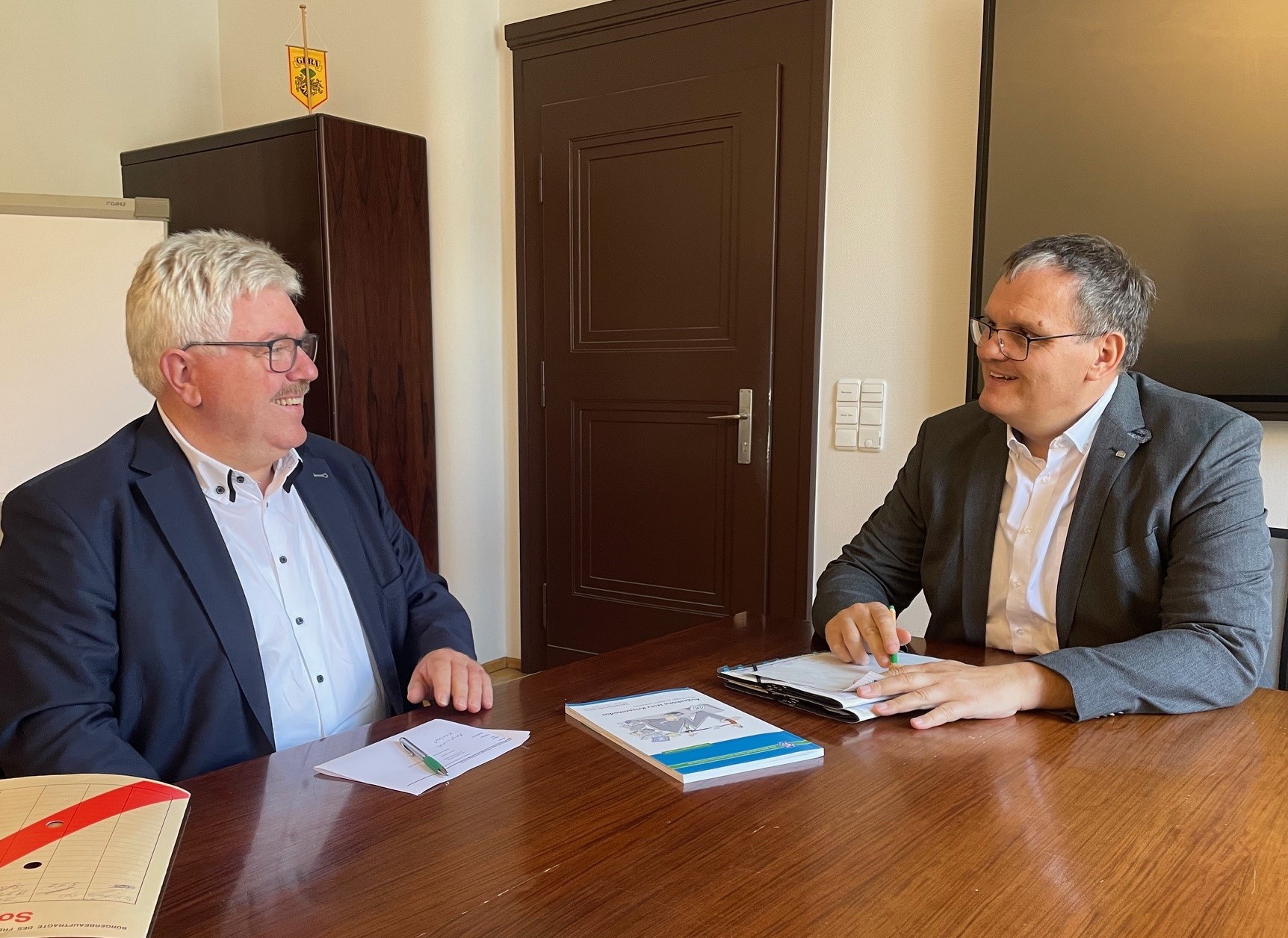 Herzberg und Dannenberg im Büro im Gespräch