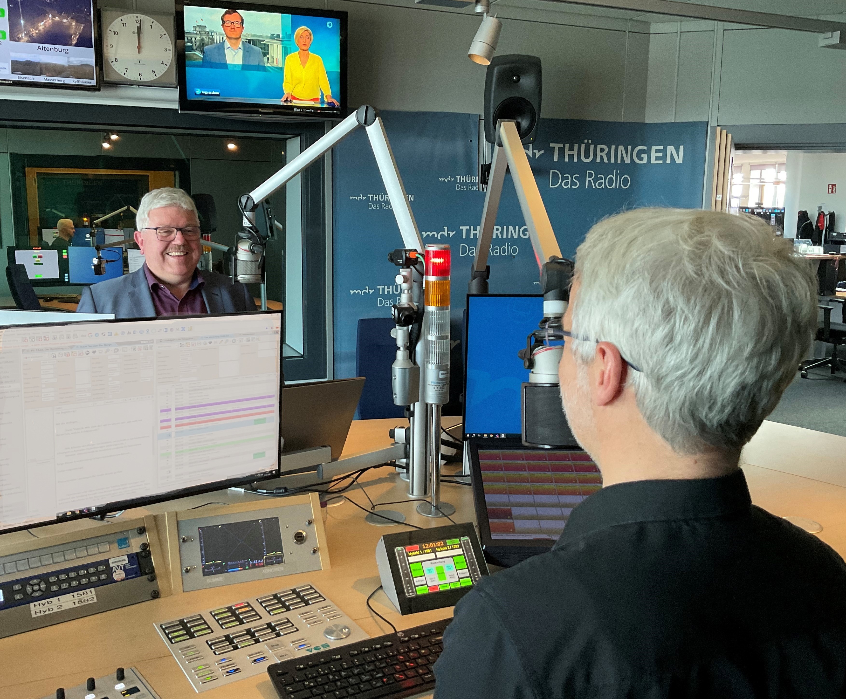 Herzberg vor Mikrofon im Studio beim MDR, im Vordergrund der Moderator von hinten